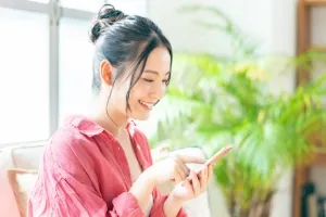 携帯電話でプランを確認する女性